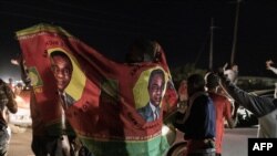 Supporters of Zambian opposition presidential candidate Hakainde Hichilema cheer in front of his residence in Lusaka, Zambia, Aug. 15, 2021, as partial election results show Hichilema with a commanding lead in votes. 