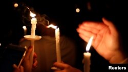 People attend a candlelight vigil for victims of yesterday's shooting at nearby Marjory Stoneman Douglas High School, in Parkland, Florida, U.S. Feb. 15, 2018. 