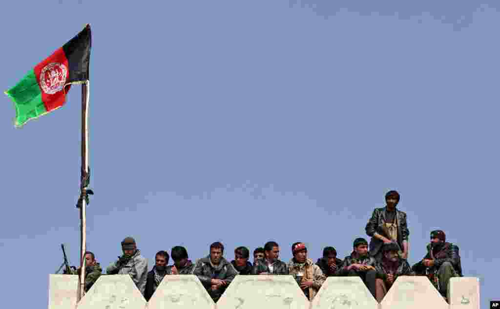 Bodyguard kandidat presiden Afghanistan Abdullah Abdullah berdiri sambil mendengarkan pidatonya dalam kampanye di distrik Deh Sabz district di pinggiran kota Kabul, 5 Maret 2014. 