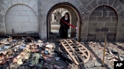 A nun looks at a heavily damaged Church of Multiplication after a fire broke out overnight near the Sea of Galilee in Tabgha, Israel, June 18, 2015.