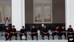 Sniffer dogs and members of Burma's bomb squad rest after checking Myanmar International Convention Center, the venue for the 24th ASEAN Summit for explosives in Naypyitaw, Burma, May 9, 2014.
