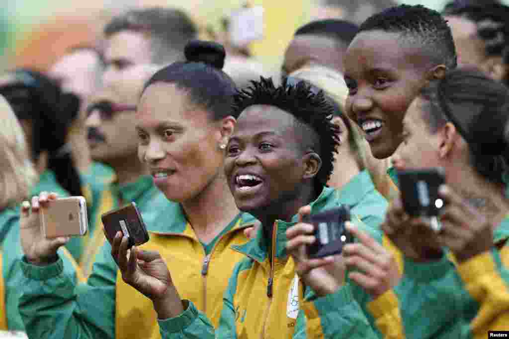 Des membres de la délégation olympique de l'Afrique du sud prennent des photos lors d'une cérémonie de bienvenue, à Rio, le 29 juillet 2016.