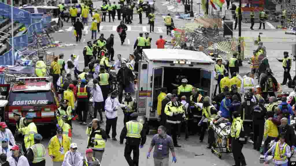 Medical workers aid injured people at the finish line of the 2013 Boston Marathon following explosions in Boston, April 15, 2013.