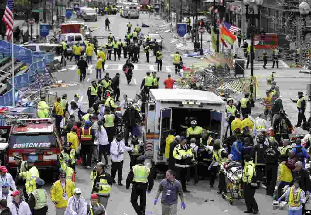 Petugas medis mengobati orang-orang yang terluka di garis finish Marathon Boston 2013 menyusul ledakan bom di Boston (15/4). (AP/Charles Krupa)