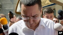 FILE - Romanian Premier Victor Ponta is surrounded by media as he exits the national anti-corruption prosecutors office.