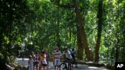 Pengunjung berjalan-jalan dan bersepeda di Taman Nasional Tijuca di Rio de Janeiro, Minggu, 28 Februari 2021. 