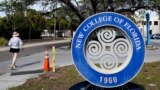 FILE - A student makes her way past the sign at New College of Florida, Jan. 20, 2023, in Sarasota, Fla. (AP Photo/Chris O'Meara, File)