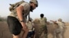 FILE - Afghan troops and US soldiers take up fighting positions after taking incoming fire in the Arghandab Valley north of Kandahar, Afghanistan, July 27, 2010.