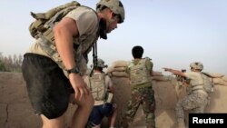 FILE - Afghan troops and US soldiers take up fighting positions after taking incoming fire in the Arghandab Valley north of Kandahar, Afghanistan, July 27, 2010.