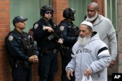 Men leave the Islamic Cultural Center of New York under increased police security following the shooting in New Zealand, March 15, 2019, in New York.