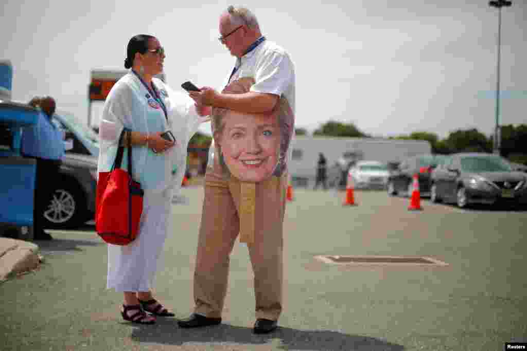 A man holds a cardboard cutout of the face of Democratic presidential nominee Hillary Clinton 