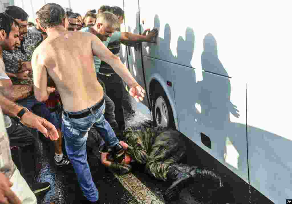 Warga menendangi dan memukuli seorang tentara Turki yang berpartisipasi dalam upaya kudeta, di Jembatan Bosporus, Istanbul (16/7). (AP/Selcuk Samiloglu)