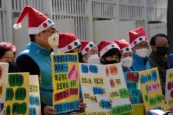 Para orang tua murid mengenakan masker, berdiri untuk mendoakan keselamatan dan kesuksesan anak-anak mereka pada malam ujian masuk perguruan tinggi di depan kompleks pemerintah di Seoul, Korea Selatan, Rabu, 17 November 2021.