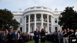 President Donald Trump and first lady Melania Trump participate in a moment of silence honoring the victims of the Sept. 11, 2001, terrorist attacks, on the South Lawn of the White House, in Washington, Sept. 11, 2019.