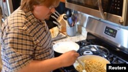 Clint Parry cooks chicken tacos at home for himself and his wife, Amanda, in Auburn Hills, Michigan, U.S., July 30, 2020. Picture taken July 30, 2020. (Amanda Parry/Handout via REUTERS)