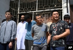 Detained Chinese nationals whose alleged involvement in a trafficking gang to lure Pakistani women into fake marriages, arrive at a court in Islamabad, Pakistan, Thursday, May 9, 2019.