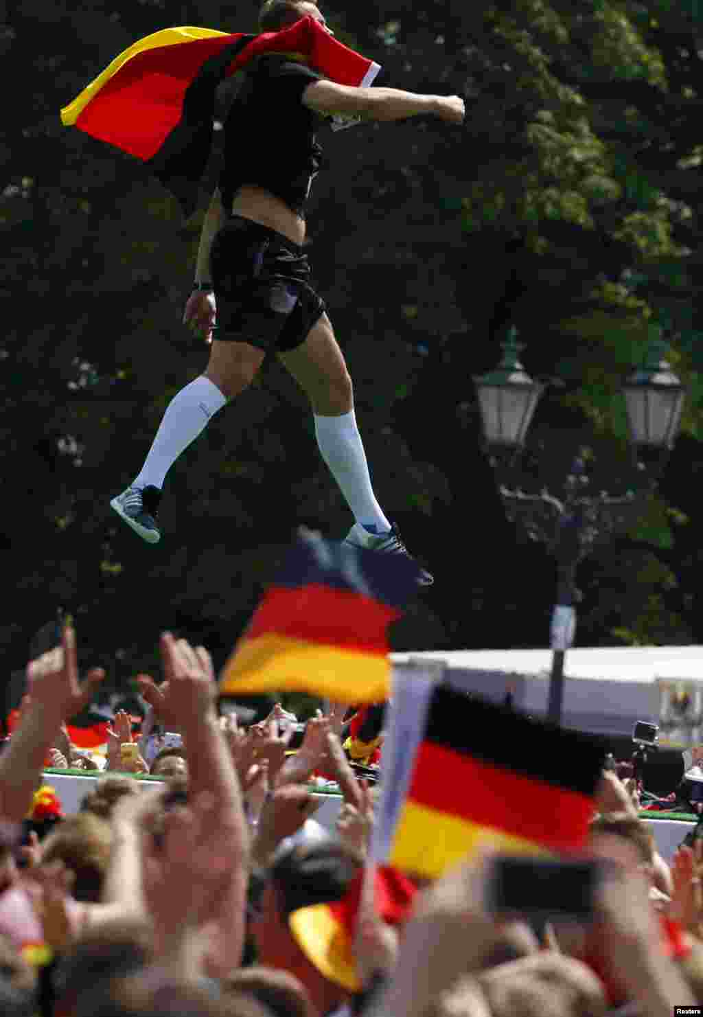 Penjaga gawang Jerman Manuel Neuer melompat ketika merayakan kemenangan timnya di Piala Dunia Brazil 2014, di tempat nobar Fan Mile di Berlin, 15 Juli 2014.