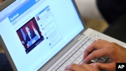 FILE - An Internet user in Los Angeles monitors a Facebook discussion board while watching televised coverage of President Barack Obama's speech from Cairo University, June 4, 2009.