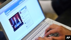 FILE - An Internet user in Los Angeles monitors a Facebook discussion board while watching televised coverage of President Barack Obama's speech from Cairo University, June 4, 2009.