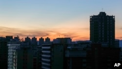 Edificios permanecen a oscuras durante un corte de energía en Caracas, Venezuela, al amanecer del viernes 30 de agosto de 2024.