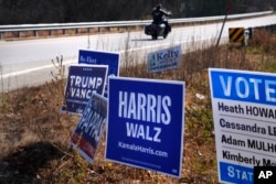 Spanduk kampanye untuk calon presiden dari Partai Republik, mantan Presiden Donald Trump, dan calon presiden dari Partai Demokrat, Wakil Presiden Kamala Harris, berjejer di sepanjang jalan raya, 31 Oktober 2024. (Foto: AP)