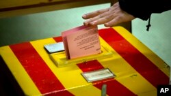 A Swiss voter casts his vote at a makeshift polling station as Swiss voters went to the polls to decide on a proposal to cap immigration to the Alpine republic, in Geneva, Switzerland, Feb. 9, 2014.