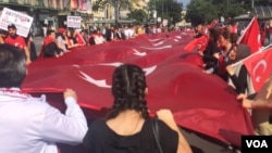 Demonstrators carry a large Turkish flag, saying they are not just protesting the attack in Istanbul, but the increasing tendency to conflate Islam and terrorism, in Vienna, Austria, July 3, 2016. (H. Murdock/VOA)