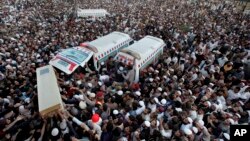 Pakistani Sunni Muslims carry the casket of a victim of Friday's sectarian clashes during funeral prayers in Rawalpindi, Pakistan, Nov. 17, 2013.