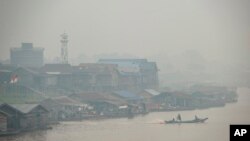 FILE - Haze from forest fires blankets villages along Kahayan river in Palangkaraya, Central Kalimantan, Indonesia, Sept. 20, 2019. Haze blown by monsoon winds from fires in Indonesia has begun affecting some areas of the Philippines.