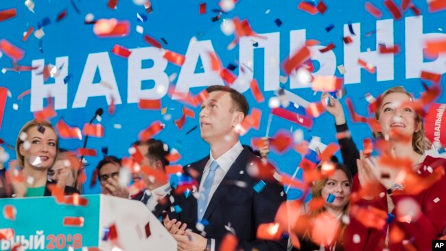 Russian opposition leader Alexei Navalny, right, and his wife Yulia, left, celebrate during a meeting that nominated him for the presidential election race in Moscow, Russia, Dec. 24, 2017.