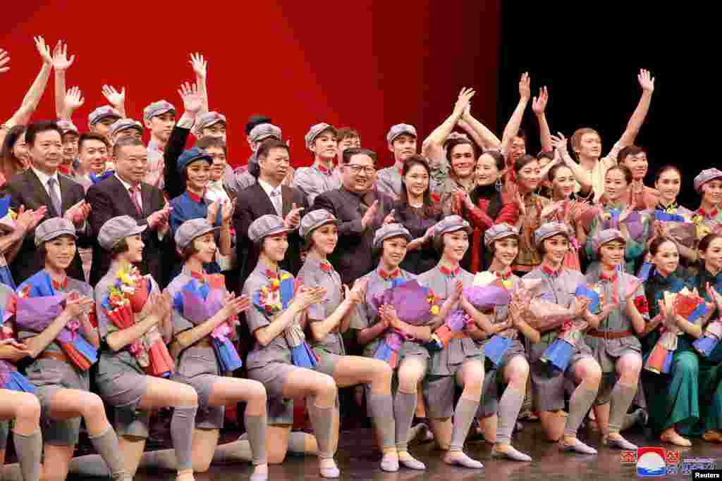 رهبر کره شمالی به همراه یک مقام حزب کمونیست چین در میان دختران رقصنده، عکس یادگاری می گیرد.