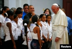 El papa Francisco conversa con niños en el santuario de la Virgen de la Caridad en El Cobre, Cuba, el 21 de septiembre de 2015.