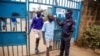 Schoolchildren have their temperature taken as they arrive at the Olympic Primary School in Kibera, one of the capital Nairobi's poorest areas in Kenya, Oct. 12, 2020.