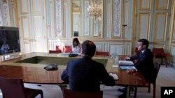 French President Emmanuel Macron, right, attends a videoconference with G20 leaders to discuss the coronavirus disease outbreak, at the Elysee Palace in Paris, March 26, 2020