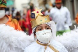 A child dressed as an angel character takes part in the Mama Negra festival in honor of the Virgin of Las Mercedes in Latacunga, Ecuador, Sept. 24, 2020.