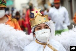 A child dressed as an angel character takes part in the Mama Negra festival in honor of the Virgin of Las Mercedes in Latacunga, Ecuador, Sept. 24, 2020.