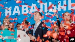 Russian opposition leader Alexei Navalny, right, and his wife Yulia, left, celebrate during a meeting that nominated him for the presidential election race in Moscow, Dec. 24, 2017. 