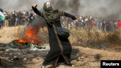 Une jeune fille lance des pierres lors d'affrontements avec les troupes israéliennes lors d'une manifestation, à l'est de la ville de Gaza.