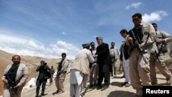 Presiden Afghanistan Hamid Karzai (tengah) menyalami warga desa korban tanah longsor yang mengungsi, saat mengunjungi mereka di distrik Argo, provinsi Badakhshan (7/5).