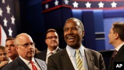 លោក​ Ben Carson (កណ្ដាល) កាល​ពី​ពេល​ធ្វើ​យុទ្ធនាការ​ឃោសនាបោះ​ឆ្នោត​ ក្នុងដំណាក់​កាល​ជជែក​ដេញដោល​លើក​ទី៣ រវាង​លោក ត្រាំ និង​លោក​ស្រី គ្លីនតុន។