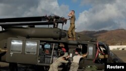 FILE - Soldiers with the U.S. Army's 1st Armored Division, Combat Aviation Brigade, work to unload a UH-60 Blackhawk helicopter from a U.S. Air Force C-5 Galaxy to aid in recovery efforts following Hurricane Maria, Puerto Rico, Oct. 4, 2017.