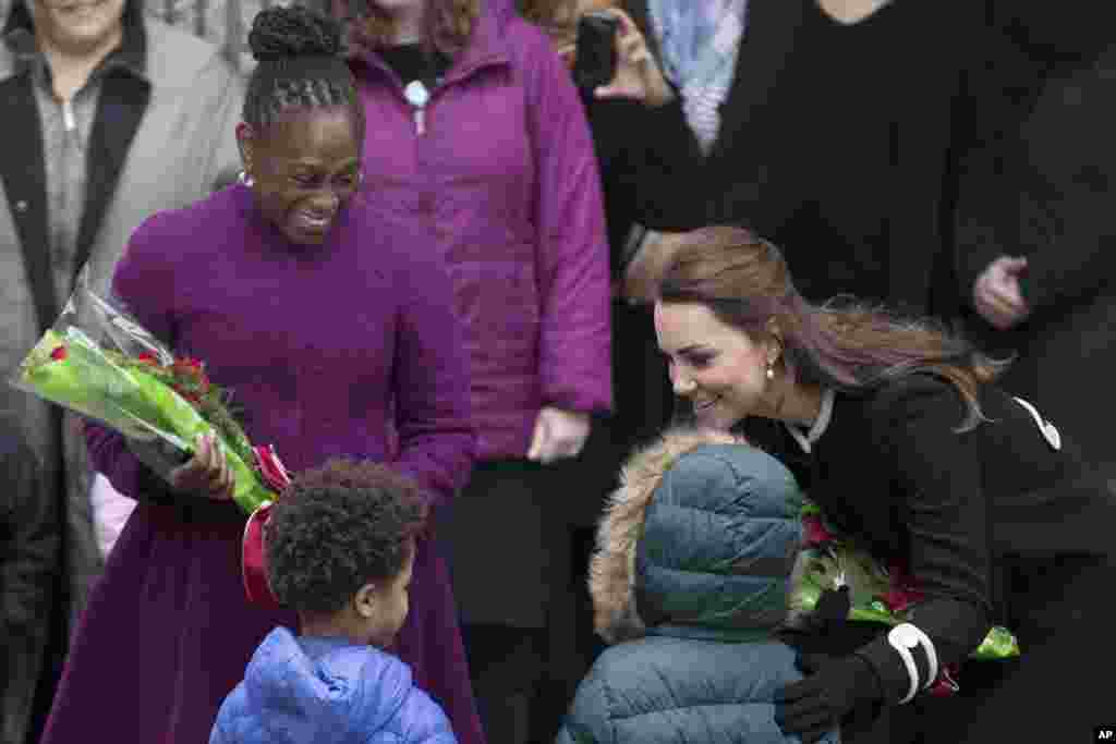 Chirlane McCray, first lady of New York City, and Britain&#39;s Kate, Duchess of Cambridge, accept flowers from students outside Northside Center for Child Development, in New York, Dec. 8, 2014.