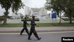 Paramilitary soldiers walk past the Supreme Court building in Islamabad, August 8, 2012. 