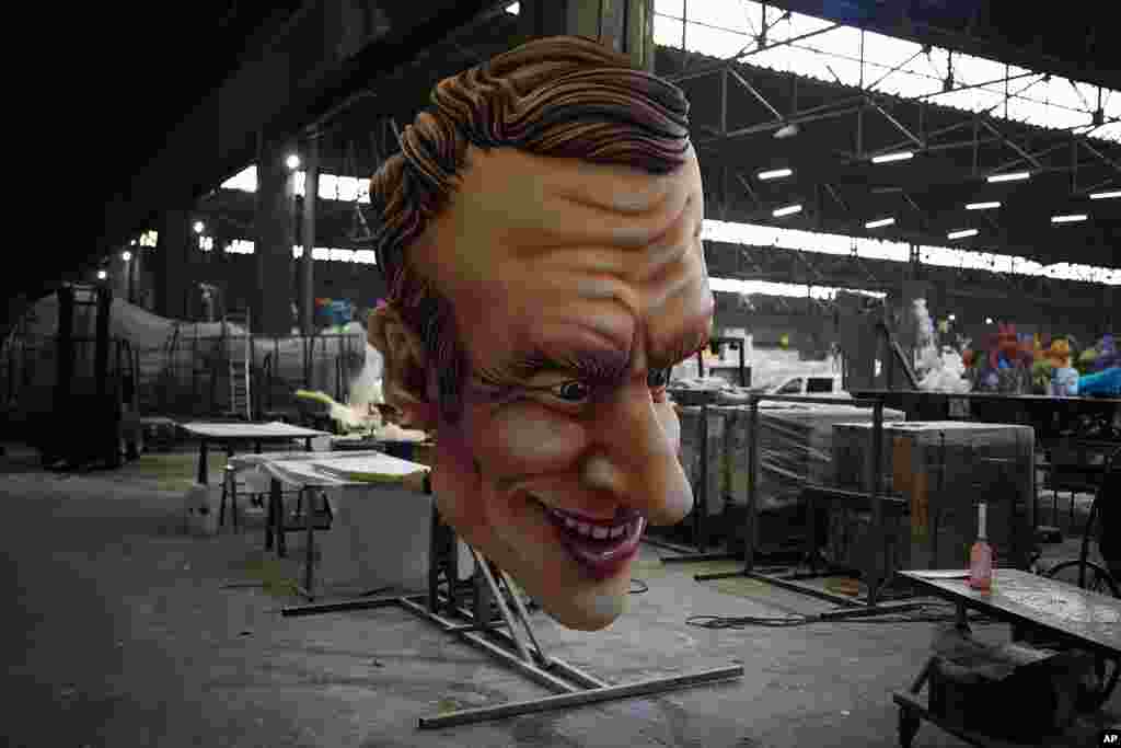 A carnival float figure of France&#39;s President Emmanuel Macron sits at a warehouse in Nice, southern France, as a celebration of nature, human connection and life after months of lockdowns, social distancing and banned public gatherings begins.