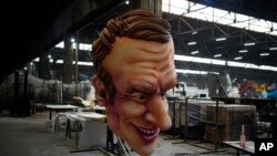 A carnival float figure of France&#39;s President Emmanuel Macron sits at a warehouse in Nice, southern France, as a celebration of nature, human connection and life after months of lockdowns, social distancing and banned public gatherings begins.