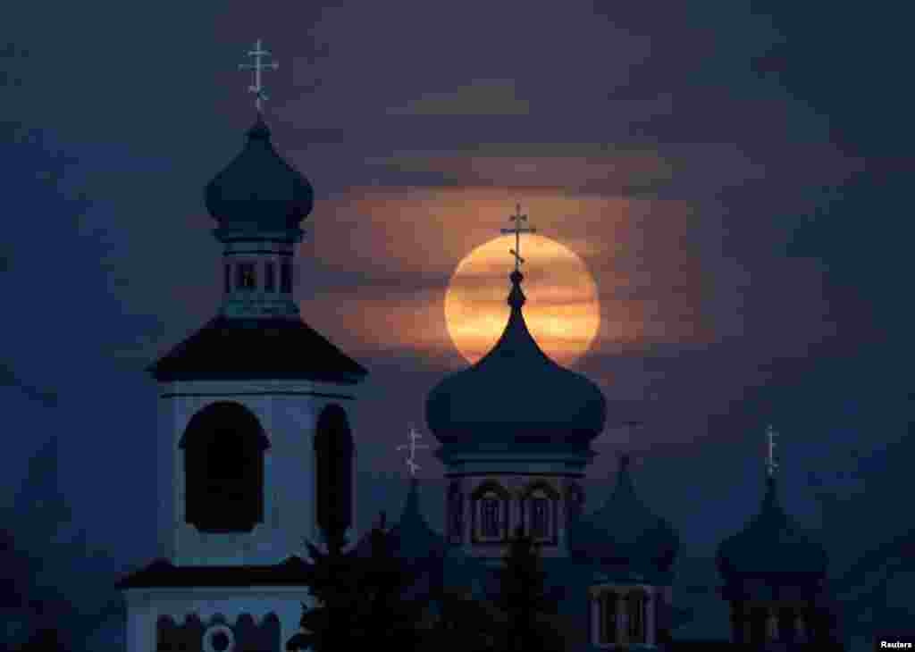 A full moon rises behind an Orthodox Church in the village of Turets, Belarus, Feb. 9, 2020.