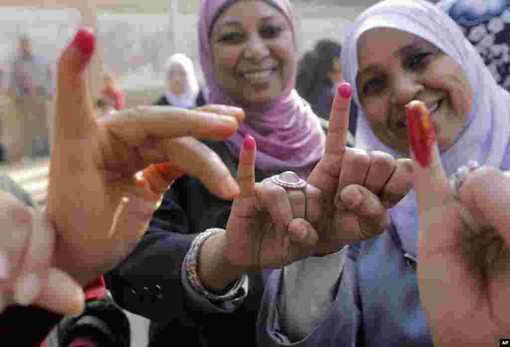 Mulheres egípcias mostram os dedos pintados depois de descarregarem o voto na urna, num local de voto no Cairo, Jan. 14, 2014. 