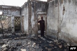 FILE— This photograph taken on March 31, 2024 shows Vice Principal Bature Sule surveying the wreckage of a dormitory destroyed by Boko Haram fighters at the Chibok Government Girls Secondary School in 2014.