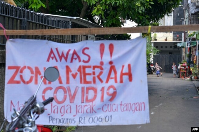 Anak-anak bermain di luar kawasan pemukimannya di Jakarta, 22 Juni 2021, saat diberlakukannya pembatasan wilayah di tengah pandemi COVID-19. (Foto: BAY ISMOYO / AFP)