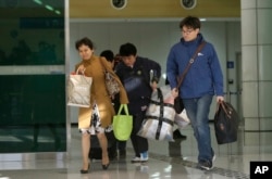 South Koreans arrive with their belongings from North Korea's Kaesong at the customs, immigration and quarantine office near the border village of Panmunjom, in Paju, north of Seoul, South Korea, April 9, 2013.